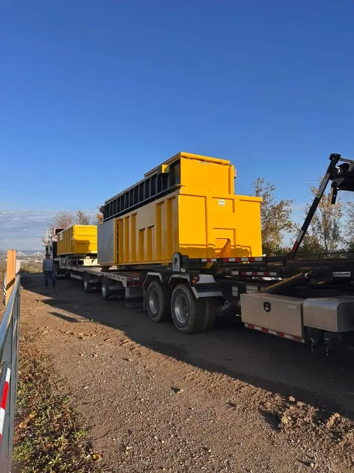 A Sullivan Disposal roll-off truck setting a dumpster on a job site.