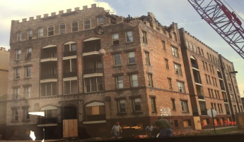 Excavator working on a multistory structural demolition.
