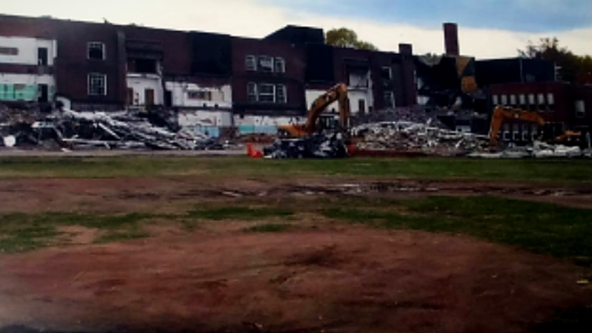 Selective demolition of a brick school building with a retained front facade.